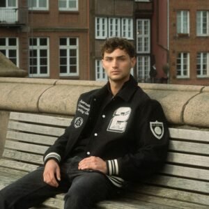 Man Wearing Baseball Jacket Sitting on a Bench